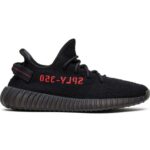 Perfil lateral do tênis Yeezy Boost 350 V2 Bred da Adidas, tecido Primeknit preto, detalhe em vermelho e sola BOOST